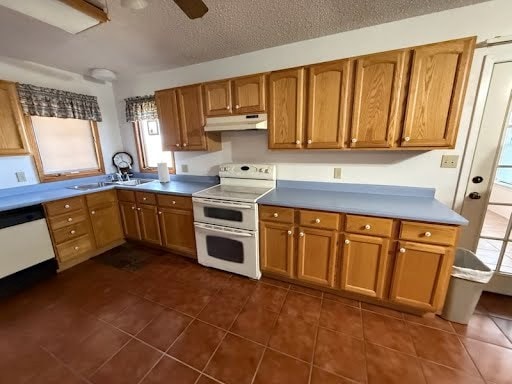 kitchen featuring white appliances, sink, a textured ceiling, ceiling fan, and dark tile patterned flooring