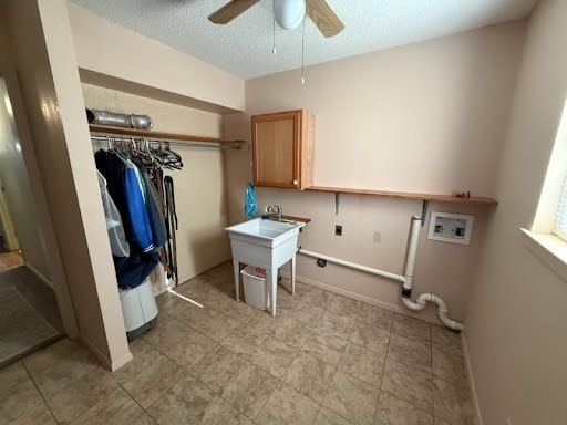 clothes washing area with hookup for a washing machine, sink, ceiling fan, electric dryer hookup, and a textured ceiling