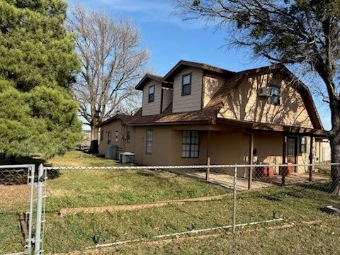 view of side of home featuring central AC unit and a lawn