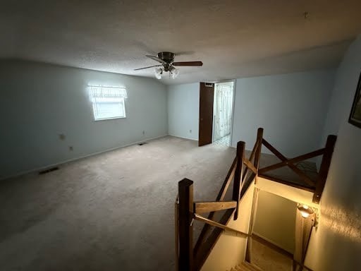 empty room featuring ceiling fan and carpet flooring