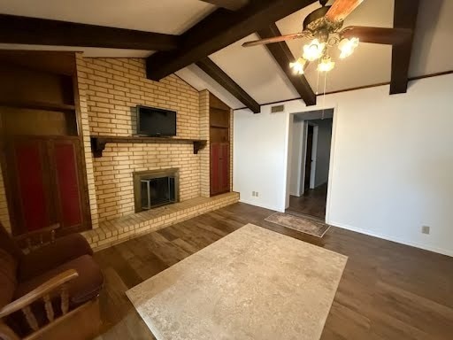 unfurnished living room featuring dark hardwood / wood-style flooring, built in shelves, vaulted ceiling with beams, and a brick fireplace