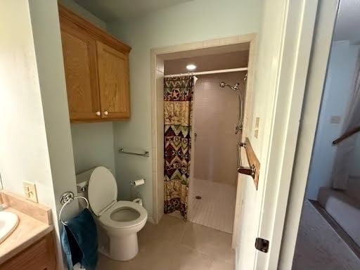 bathroom with toilet, tile patterned floors, curtained shower, and vanity