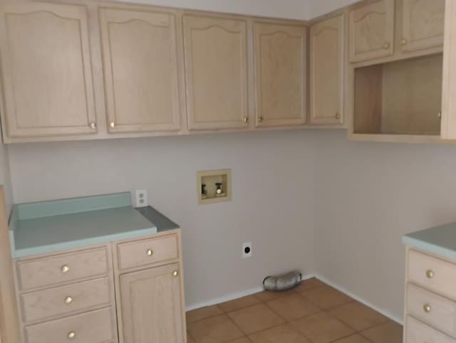1246 E 20th St, San Angelo, TX 76903 - washroom featuring hookup for a washing machine, hookup for an electric dryer, cabinet space, and light tile patterned floors