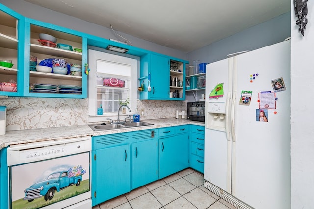 kitchen with light tile patterned flooring, blue cabinets, sink, decorative backsplash, and white appliances