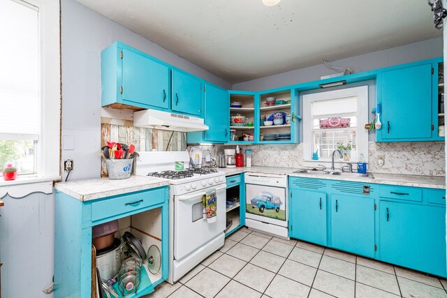 kitchen with blue cabinets, sink, light tile patterned floors, white appliances, and decorative backsplash