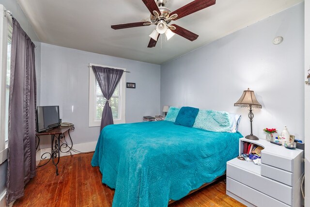 bedroom with dark hardwood / wood-style flooring and ceiling fan