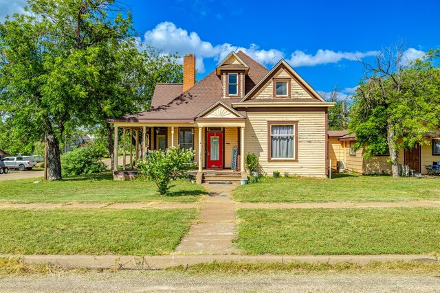 view of front of property featuring a front yard and covered porch