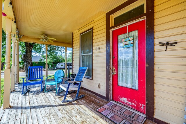 doorway to property featuring ceiling fan and a porch