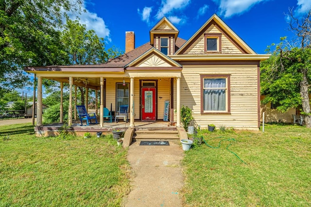 view of front of property featuring covered porch and a front yard