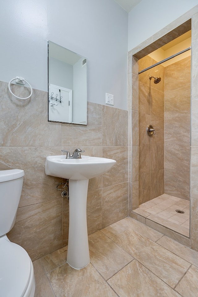 5438 S Loop 306, San Angelo, TX 76905 - full bathroom with toilet, tile walls, tiled shower, and wainscoting
