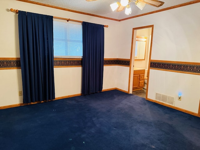 carpeted spare room featuring ceiling fan, ornamental molding, and a textured ceiling