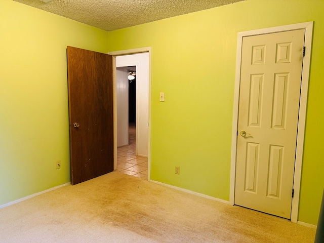 unfurnished bedroom featuring light carpet and a textured ceiling