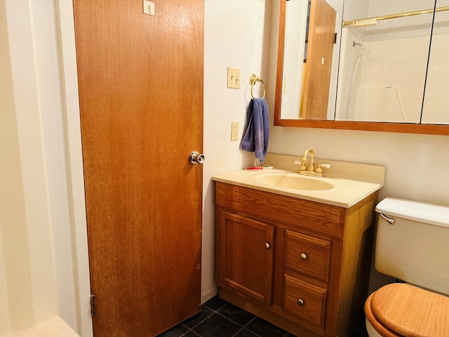 bathroom featuring vanity, walk in shower, tile patterned floors, and toilet