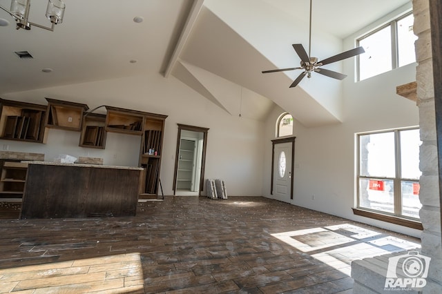 unfurnished living room with beamed ceiling, high vaulted ceiling, and ceiling fan