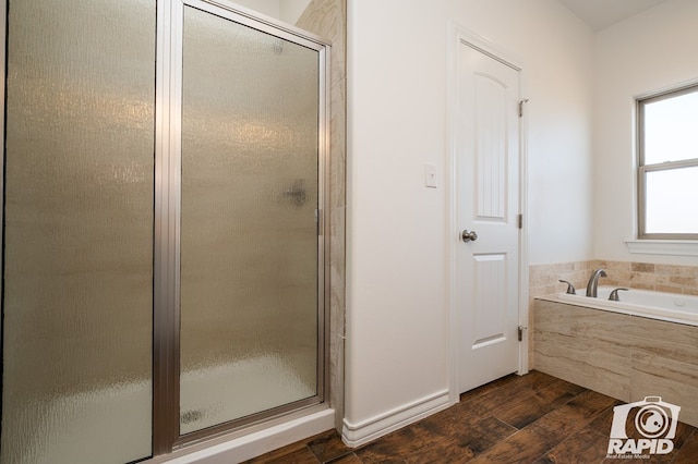 full bath with a bath, a stall shower, and wood finished floors