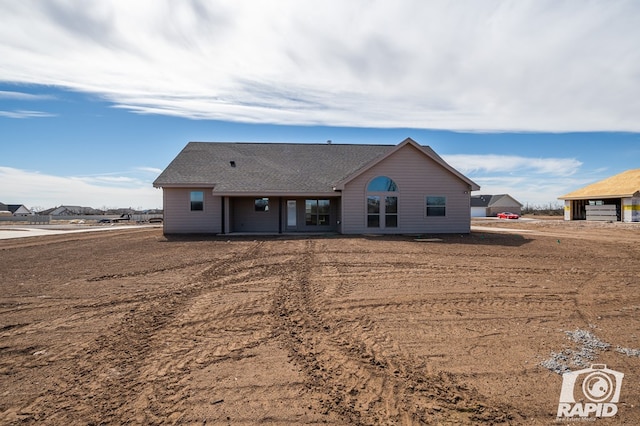 back of property featuring roof with shingles