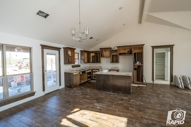 kitchen with an inviting chandelier, a kitchen island, decorative light fixtures, stainless steel dishwasher, and beamed ceiling