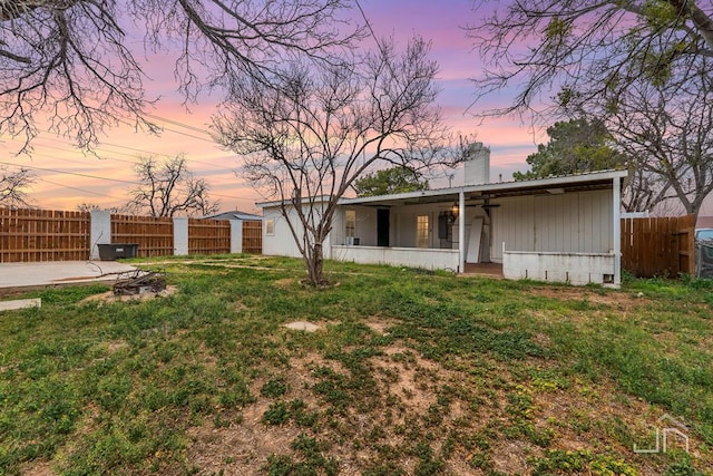 view of front of house featuring a patio area, a front yard, and fence