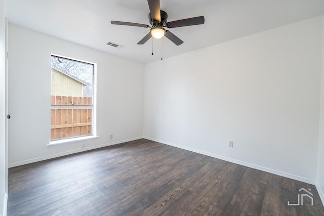 empty room with visible vents, baseboards, ceiling fan, and dark wood-style flooring