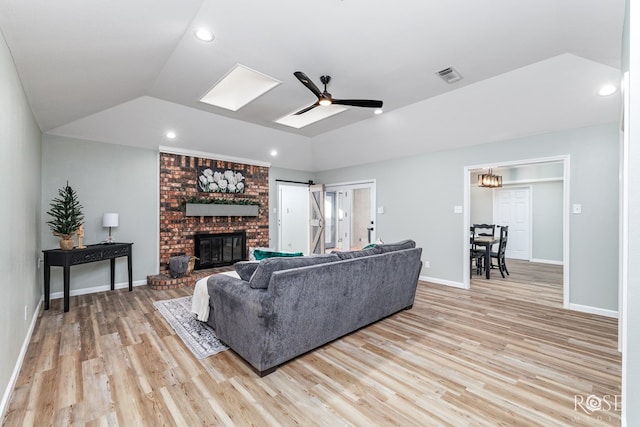 living room featuring ceiling fan, lofted ceiling, and light wood-type flooring