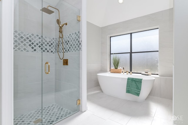 bathroom with tile patterned flooring, separate shower and tub, and tile walls