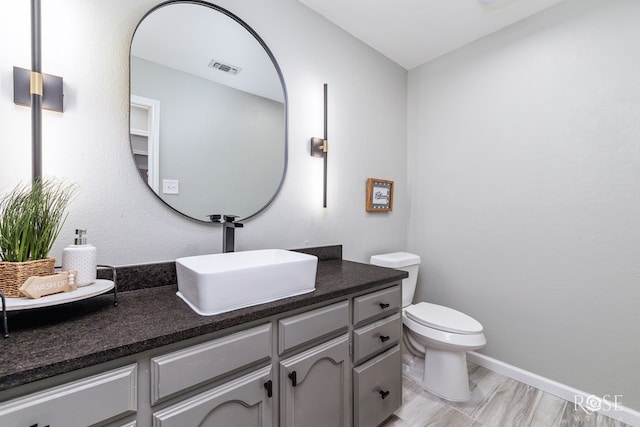 bathroom featuring vanity, hardwood / wood-style floors, and toilet