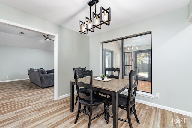 dining area featuring ceiling fan with notable chandelier and light wood-type flooring