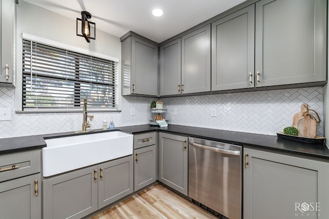 kitchen featuring sink, light hardwood / wood-style flooring, gray cabinets, dishwasher, and tasteful backsplash