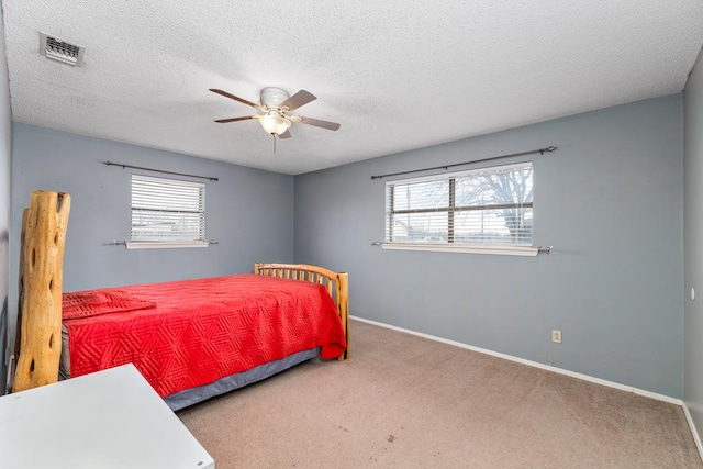 bedroom featuring baseboards, multiple windows, visible vents, and carpet flooring