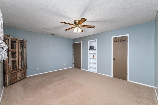 unfurnished bedroom featuring baseboards, a textured ceiling, visible vents, and carpet flooring