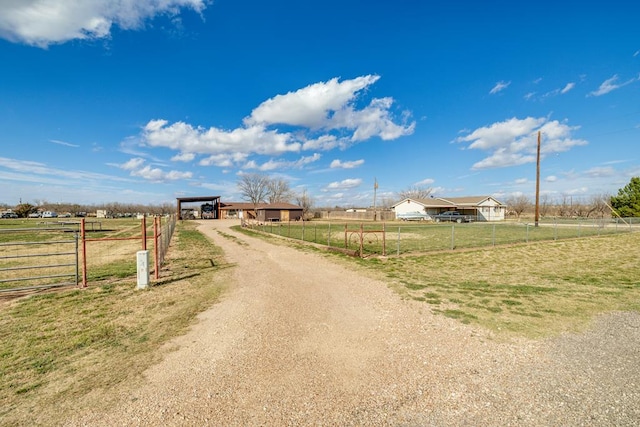 view of street with an outbuilding, driveway, and a rural view