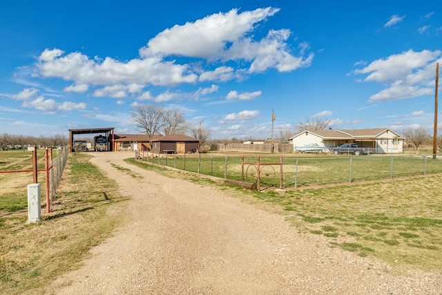 view of street featuring an outbuilding, a rural view, and dirt driveway