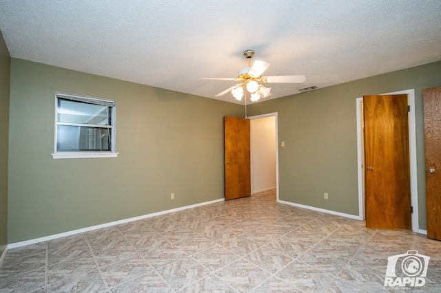 unfurnished room featuring ceiling fan and a textured ceiling