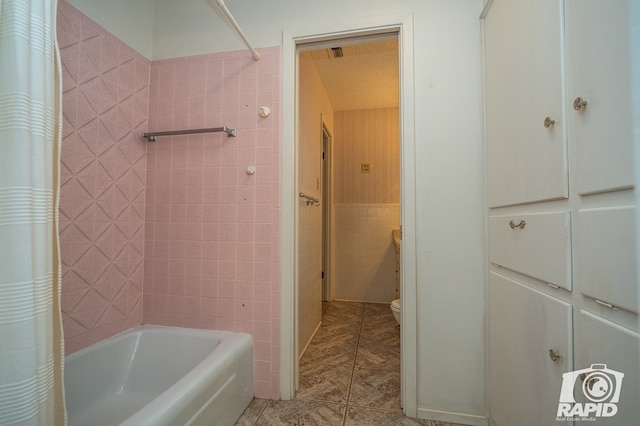 bathroom featuring shower / tub combo and toilet