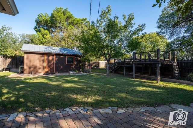 view of yard featuring a deck and a storage shed