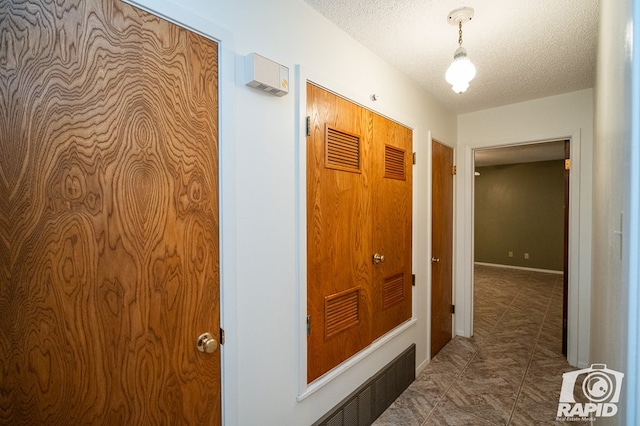 hallway with a textured ceiling