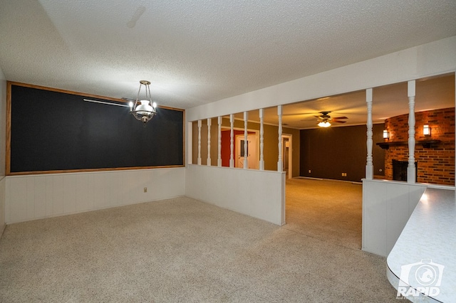 unfurnished room with carpet flooring, ceiling fan with notable chandelier, and a textured ceiling