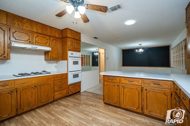 kitchen with white appliances, a textured ceiling, ceiling fan, light hardwood / wood-style floors, and decorative backsplash