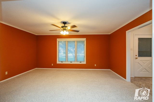 unfurnished room featuring ceiling fan, ornamental molding, and carpet