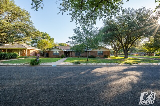 ranch-style home featuring a front lawn