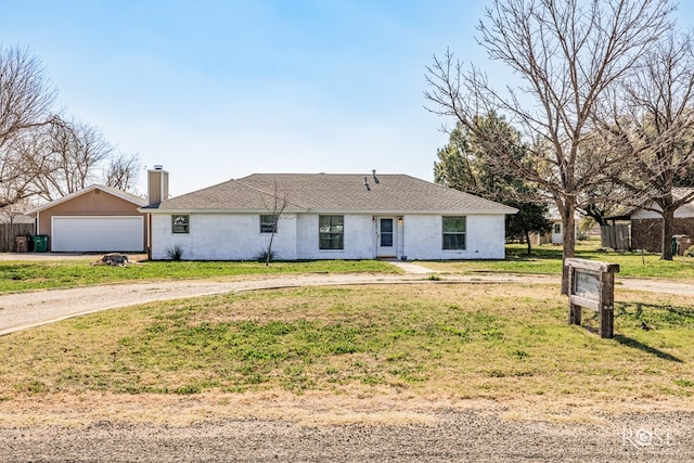 single story home featuring a garage and a front lawn