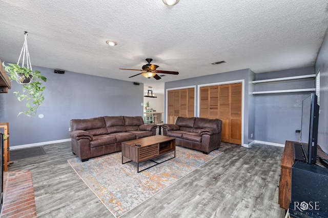 living room with hardwood / wood-style floors, a textured ceiling, and ceiling fan