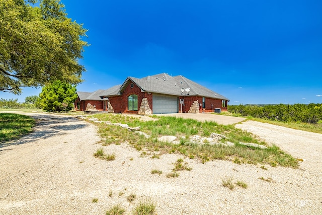 view of front of home with brick siding, driveway, and an attached garage