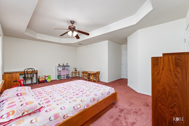 carpeted bedroom with ornamental molding, a tray ceiling, visible vents, and a ceiling fan