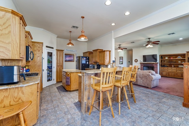 kitchen with a peninsula, a brick fireplace, visible vents, and freestanding refrigerator