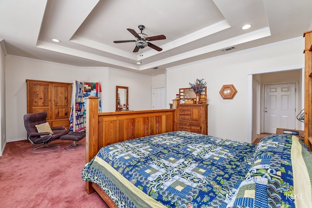 bedroom featuring carpet floors, a tray ceiling, visible vents, and crown molding