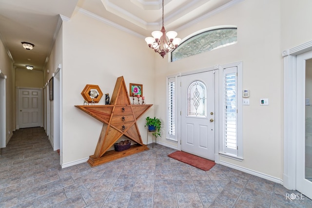 foyer featuring baseboards, ornamental molding, and a chandelier