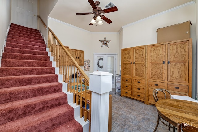 stairs featuring ornamental molding, visible vents, and ceiling fan