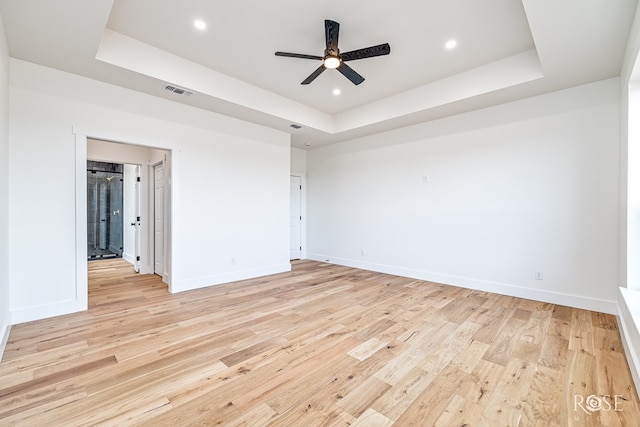 9401 Collett Rd, Robert Lee, TX 76945 - unfurnished bedroom featuring a tray ceiling, light wood finished floors, recessed lighting, connected bathroom, and a ceiling fan