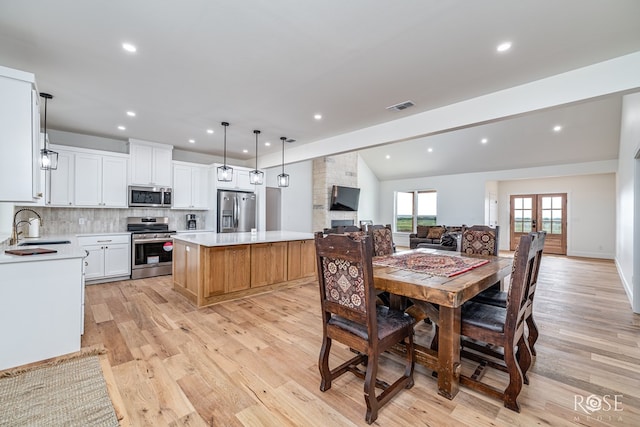 9401 Collett Rd, Robert Lee, TX 76945 - dining area featuring light wood-type flooring, vaulted ceiling, recessed lighting, and a fireplace